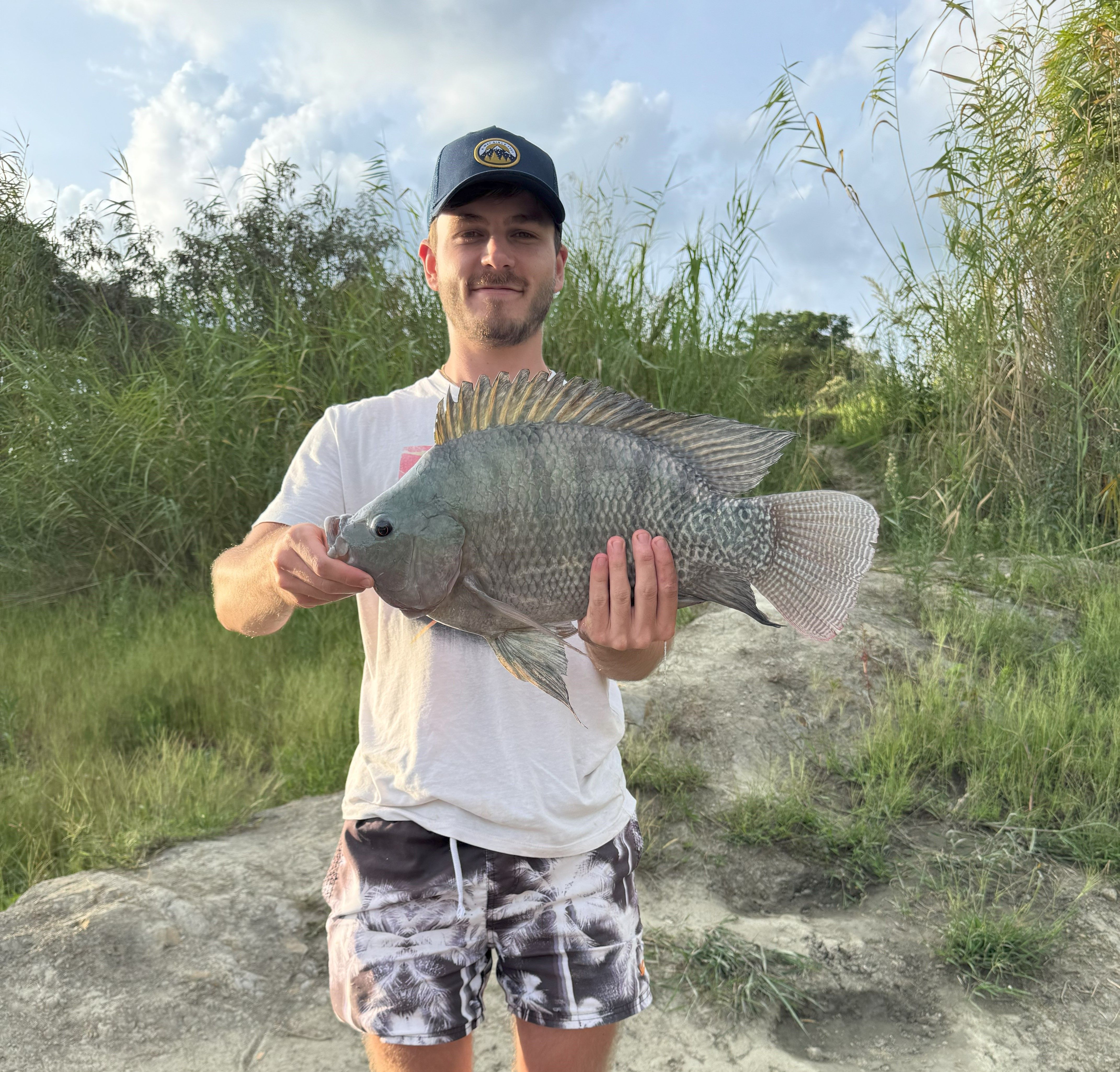 A visitor holding up a large bream caught at the park